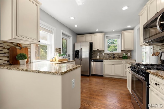7603 Devonshire Ave, Shrewsbury, MO 63119 - kitchen featuring stainless steel appliances, backsplash, dark wood-style floors, recessed lighting, and light stone counters