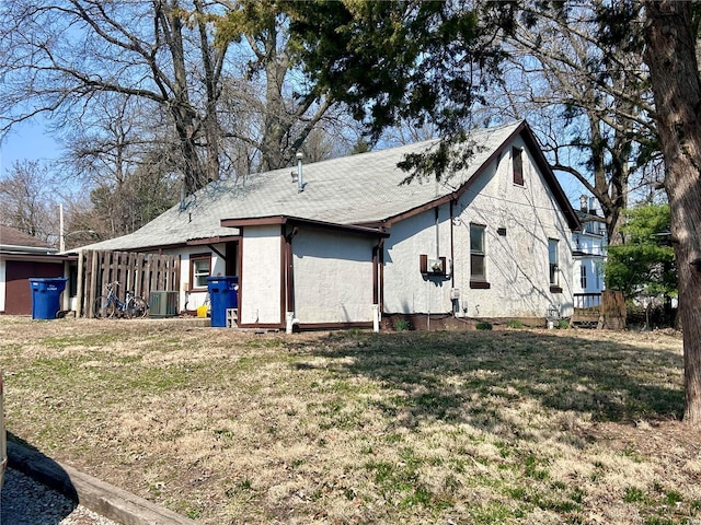 517 Mascoutah Ave, Belleville, IL 62220 - view of property exterior featuring cooling unit, a yard, stucco siding, and a shingled roof