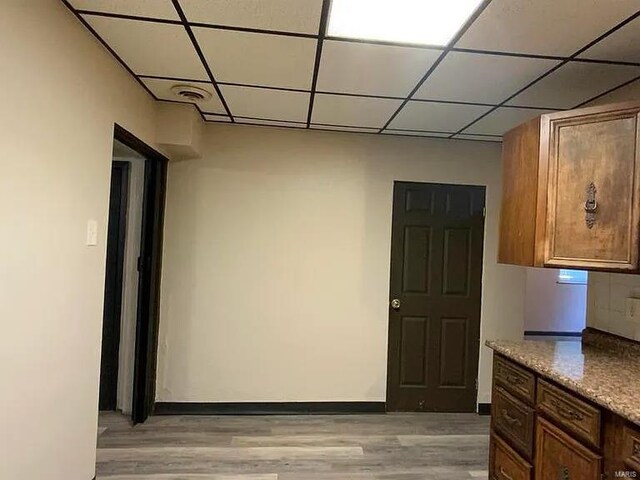 517 Mascoutah Ave, Belleville, IL 62220 - kitchen with light wood-style flooring, a paneled ceiling, brown cabinetry, and baseboards
