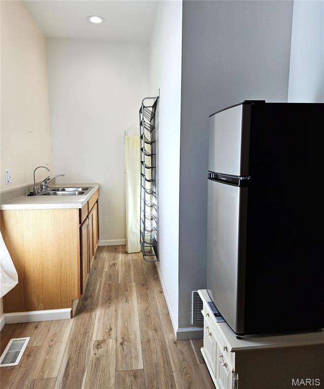 bathroom with a sink, wood finished floors, baseboards, and recessed lighting