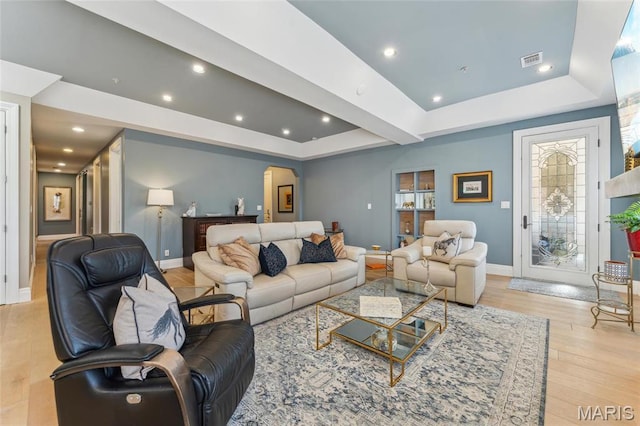 4411 Mcpherson Ave Unit 3, Saint Louis, MO 63108 - living room with arched walkways, a raised ceiling, baseboards, light wood finished floors, and recessed lighting
