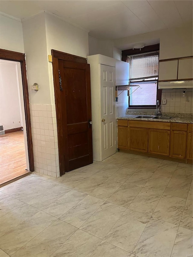 3923 Gravois Ave, Saint Louis, MO 63116 - kitchen with a sink, brown cabinets, under cabinet range hood, and stone countertops