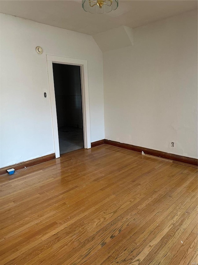 3923 Gravois Ave, Saint Louis, MO 63116 - empty room with light wood-type flooring, baseboards, a chandelier, and lofted ceiling