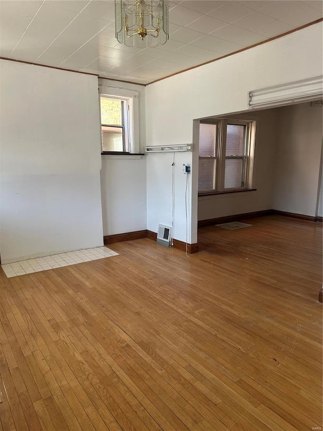 3923 Gravois Ave, Saint Louis, MO 63116 - unfurnished room featuring a chandelier, hardwood / wood-style flooring, and baseboards