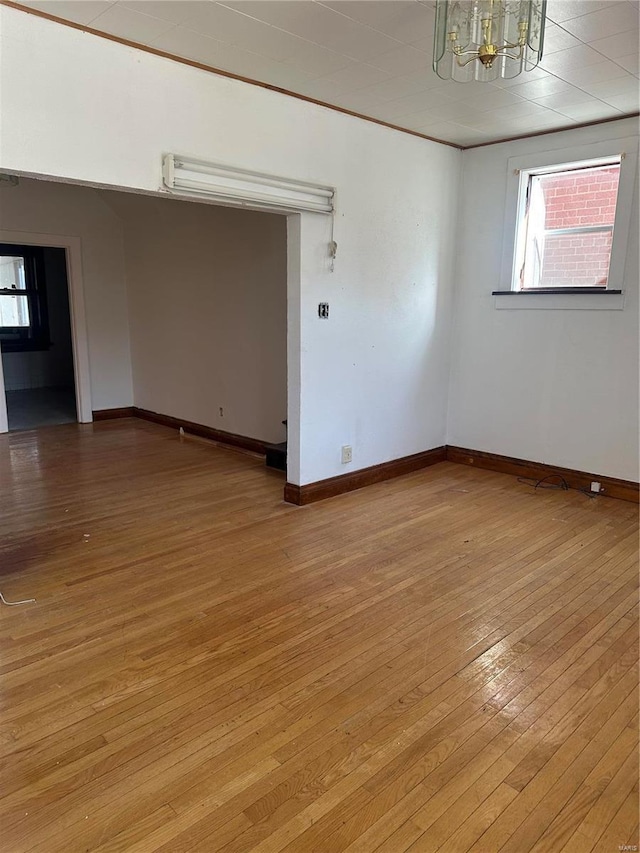 3923 Gravois Ave, Saint Louis, MO 63116 - spare room with a chandelier, light wood finished floors, plenty of natural light, and baseboards