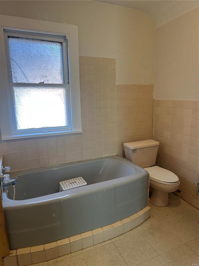 3923 Gravois Ave, Saint Louis, MO 63116 - bathroom with tile walls, toilet, a bath, and a wainscoted wall