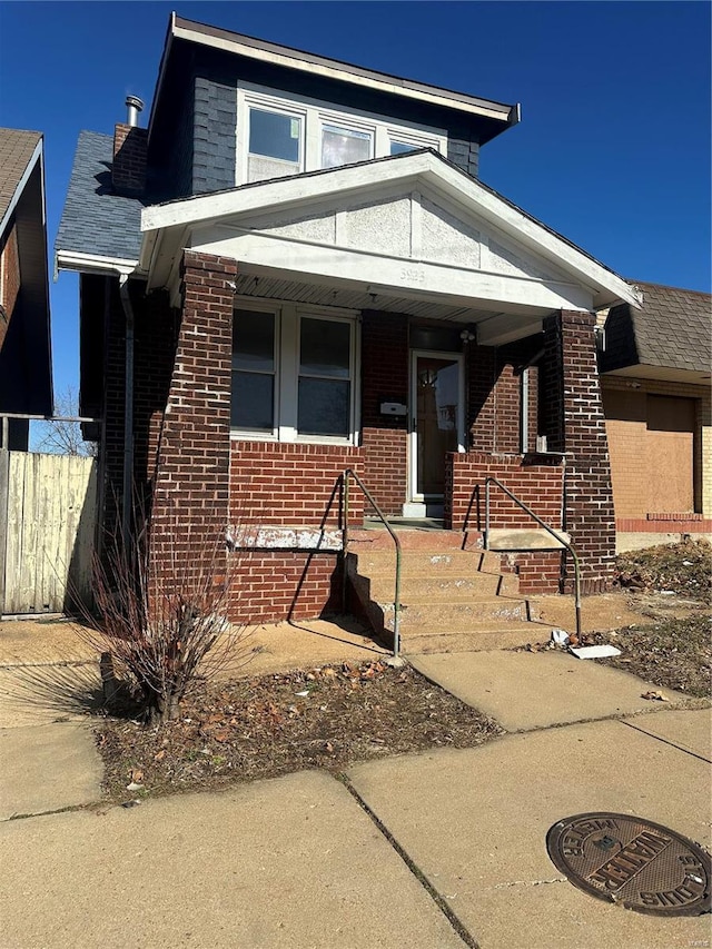 3923 Gravois Ave, Saint Louis, MO 63116 - view of front of house featuring brick siding, fence, and a porch