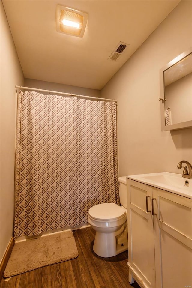 bathroom with wood finished floors, toilet, vanity, and a shower with curtain