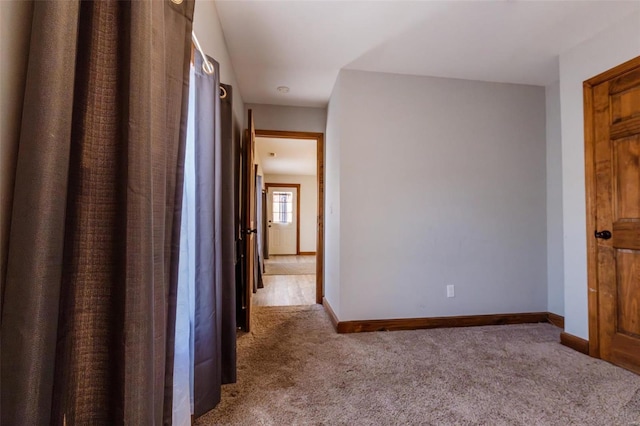corridor featuring carpet flooring and baseboards