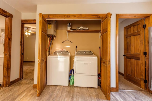 laundry area featuring washer and dryer, water heater, and light wood finished floors