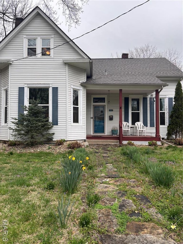 911 Grand Ave, Edwardsville, IL 62025 - view of front of home with covered porch, a chimney, a front yard, and a shingled roof
