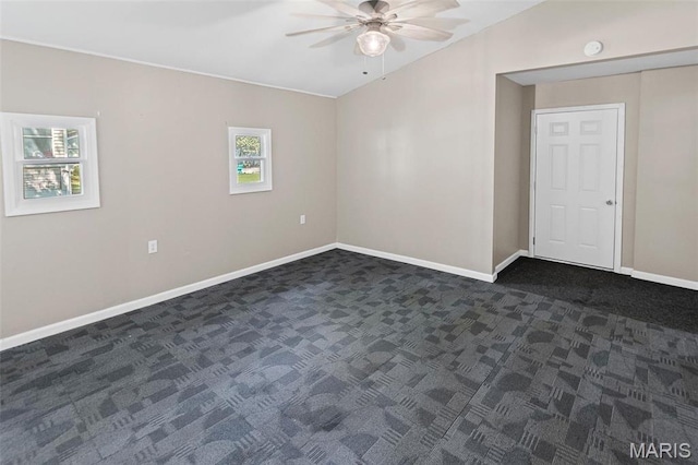 911 Grand Ave, Edwardsville, IL 62025 - spare room featuring ceiling fan, dark colored carpet, baseboards, vaulted ceiling, and a smoke detector