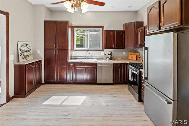 911 Grand Ave, Edwardsville, IL 62025 - kitchen featuring appliances with stainless steel finishes, a sink, a ceiling fan, light countertops, and light wood-style floors