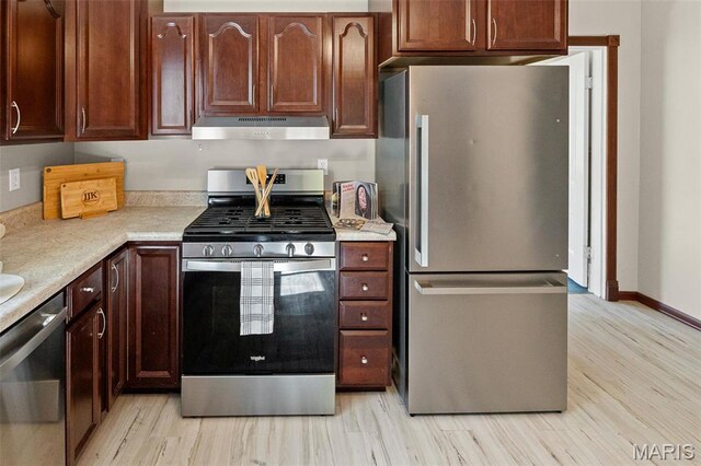 911 Grand Ave, Edwardsville, IL 62025 - kitchen with appliances with stainless steel finishes, under cabinet range hood, light wood-type flooring, and light countertops