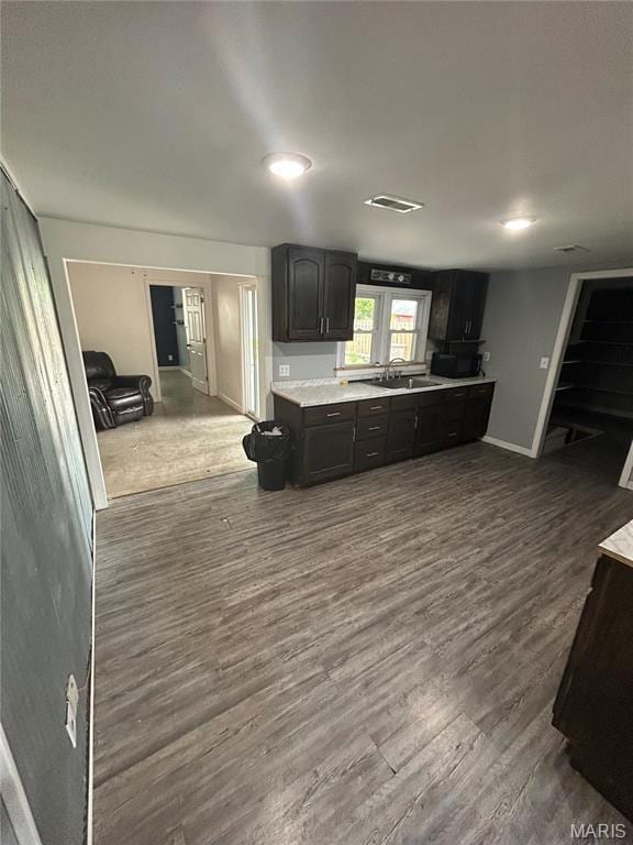 308 N Broadwater St, New Florence, MO 63363 - kitchen featuring dark wood-style floors, baseboards, a sink, light countertops, and dark cabinetry
