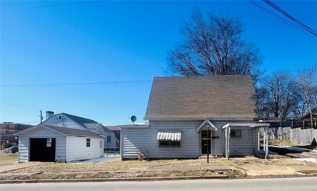 view of front of property with fence and roof with shingles