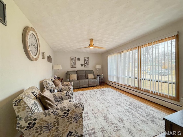 134 Pine St, Farmington, MO 63640 - living room with a baseboard radiator, ceiling fan, a textured ceiling, and wood finished floors