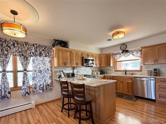 134 Pine St, Farmington, MO 63640 - kitchen with stainless steel appliances, a sink, light countertops, tasteful backsplash, and baseboard heating