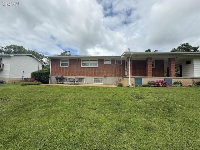 134 Pine St, Farmington, MO 63640 - back of house with a lawn, brick siding, a chimney, and a patio