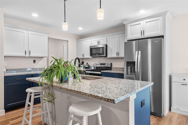 948 Half Moon, Caseyville, IL 62232 - kitchen with stainless steel appliances, a sink, light wood finished floors, a kitchen breakfast bar, and hanging light fixtures