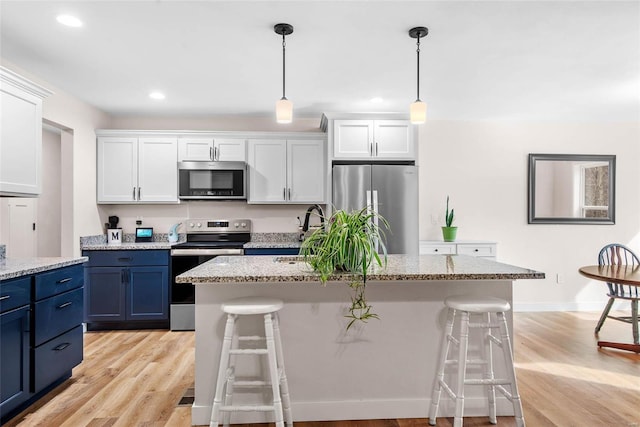 948 Half Moon, Caseyville, IL 62232 - kitchen with appliances with stainless steel finishes, blue cabinetry, a kitchen bar, white cabinets, and recessed lighting
