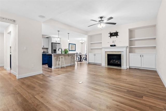 948 Half Moon, Caseyville, IL 62232 - living room featuring ceiling fan, baseboards, built in shelves, and a fireplace with flush hearth