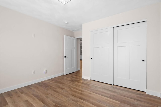 948 Half Moon, Caseyville, IL 62232 - unfurnished bedroom featuring baseboards, wood finished floors, and a closet