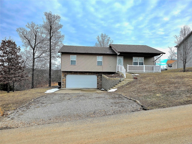 15872 Tundra St, Saint Robert, MO 65584 - view of front facade featuring driveway, stone siding, an attached garage, covered porch, and stairway