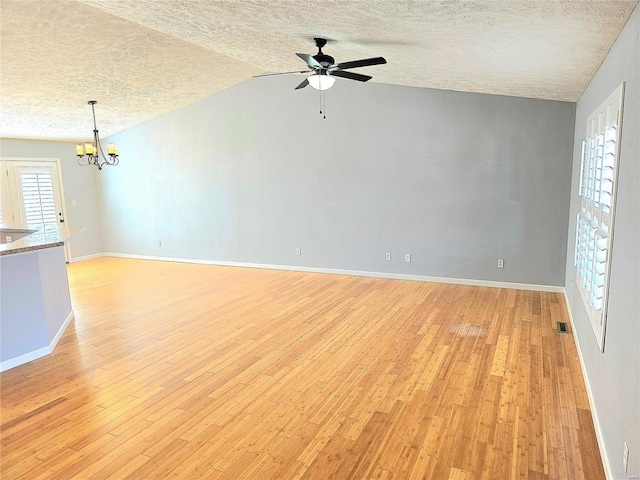 15872 Tundra St, Saint Robert, MO 65584 - empty room featuring a textured ceiling, light wood-style floors, a chandelier, ceiling fan, and baseboards
