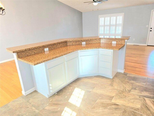 15872 Tundra St, Saint Robert, MO 65584 - kitchen with ceiling fan, light wood-type flooring, light stone counters, and baseboards