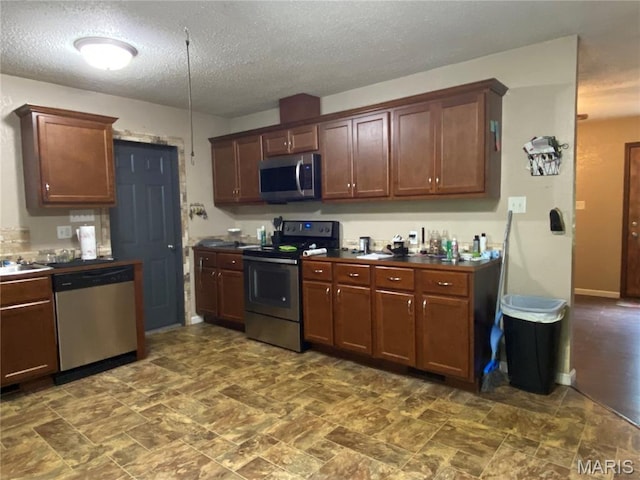 207 Navaho Dr, Cape Girardeau, MO 63701 - kitchen featuring appliances with stainless steel finishes, dark countertops, and a textured ceiling