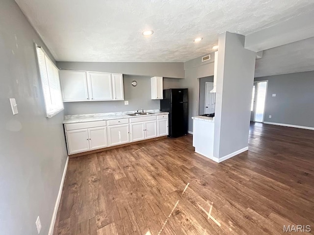 750 Robinwood Dr, Florissant, MO 63033 - kitchen featuring freestanding refrigerator, light countertops, wood finished floors, white cabinetry, and a textured ceiling