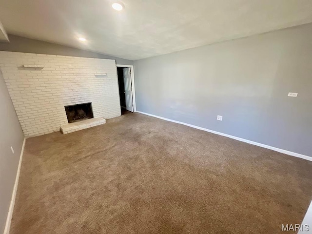 750 Robinwood Dr, Florissant, MO 63033 - unfurnished living room with a brick fireplace, vaulted ceiling, and carpet floors