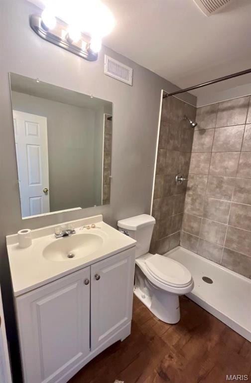 750 Robinwood Dr, Florissant, MO 63033 - bathroom featuring wood finished floors, vanity, and a tile shower