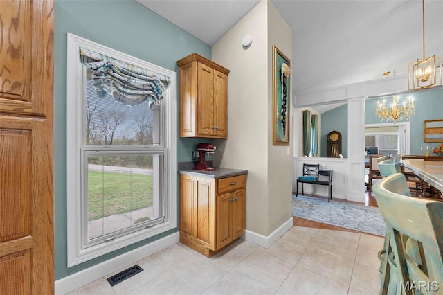 149 Windy Point Ave, Cape Girardeau, MO 63701 - kitchen featuring a chandelier, light tile patterned floors, baseboards, pendant lighting, and brown cabinets