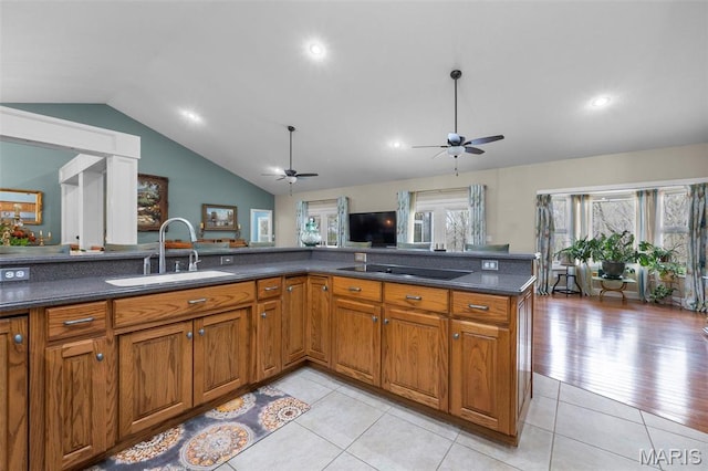 149 Windy Point Ave, Cape Girardeau, MO 63701 - kitchen featuring a sink, vaulted ceiling, a ceiling fan, brown cabinetry, and dark countertops
