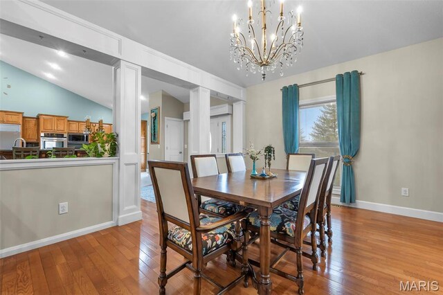 149 Windy Point Ave, Cape Girardeau, MO 63701 - dining room featuring hardwood / wood-style flooring, lofted ceiling, baseboards, a chandelier, and decorative columns