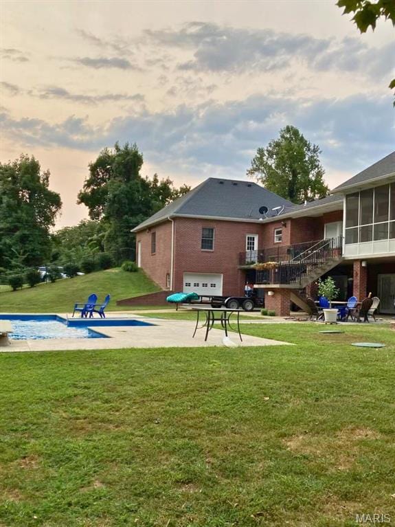 149 Windy Point Ave, Cape Girardeau, MO 63701 - rear view of property featuring an attached garage, stairs, brick siding, a yard, and a sunroom