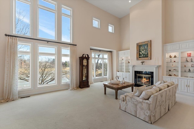 230 W Waters Edge Dr, Belleville, IL 62221 - living area with a towering ceiling, carpet, a glass covered fireplace, and built in shelves