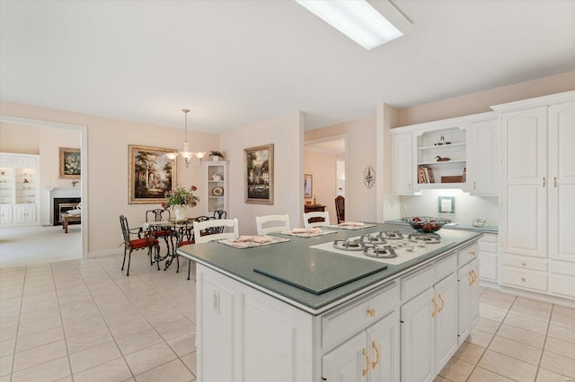 230 W Waters Edge Dr, Belleville, IL 62221 - kitchen with white gas cooktop, light tile patterned floors, open shelves, a chandelier, and a center island
