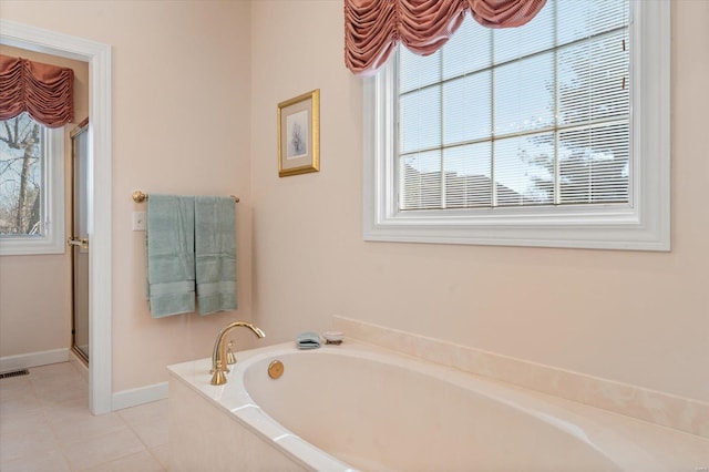 230 W Waters Edge Dr, Belleville, IL 62221 - bathroom featuring tile patterned flooring, baseboards, a bath, and a stall shower