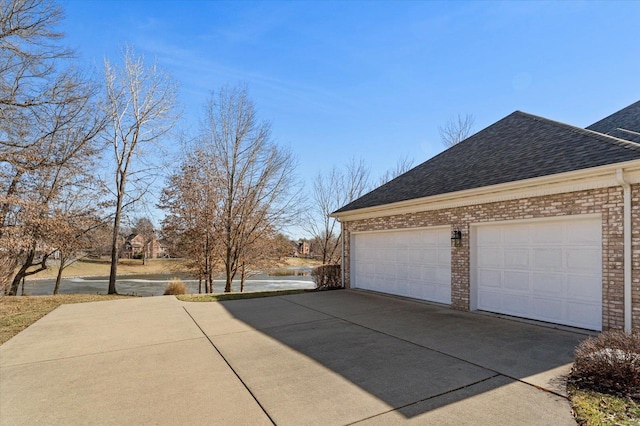 230 W Waters Edge Dr, Belleville, IL 62221 - view of side of property featuring driveway, roof with shingles, brick siding, and a garage