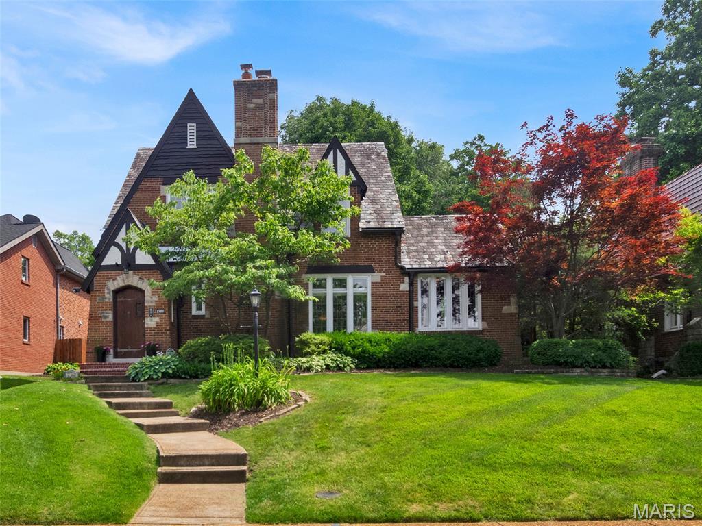 7360 Teasdale Ave, Saint Louis, MO 63130 - tudor-style house with a front lawn, a chimney, and brick siding