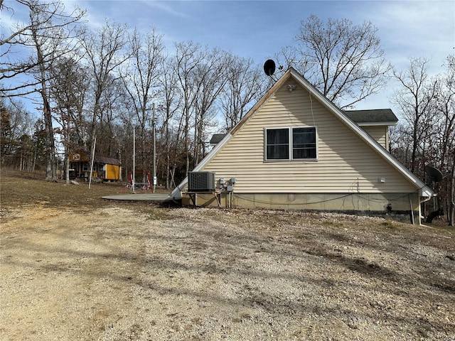 view of side of home featuring central AC and an outdoor structure