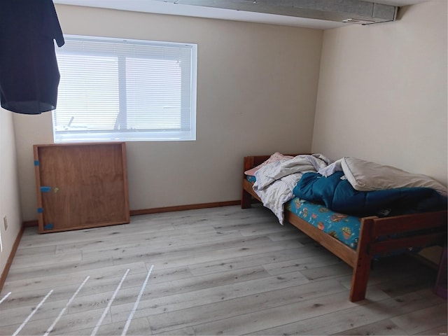 bedroom with light wood-style flooring and baseboards