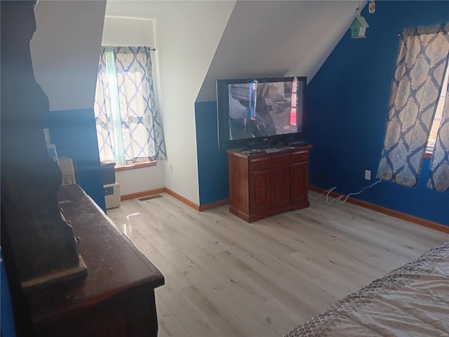 additional living space featuring light wood-style flooring, lofted ceiling, and baseboards