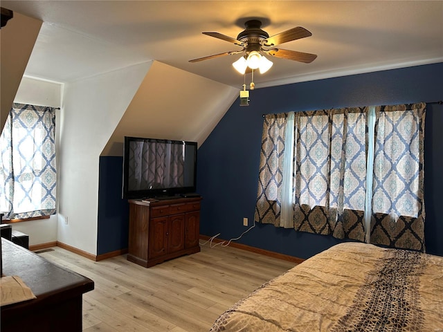 bedroom featuring light wood-style floors, baseboards, a ceiling fan, and lofted ceiling
