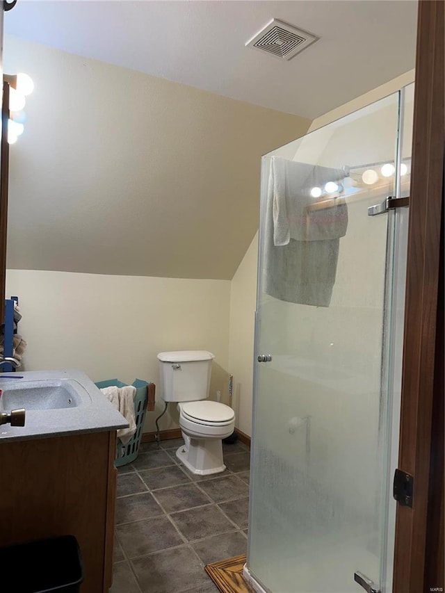 bathroom with a stall shower, toilet, vanity, vaulted ceiling, and tile patterned flooring