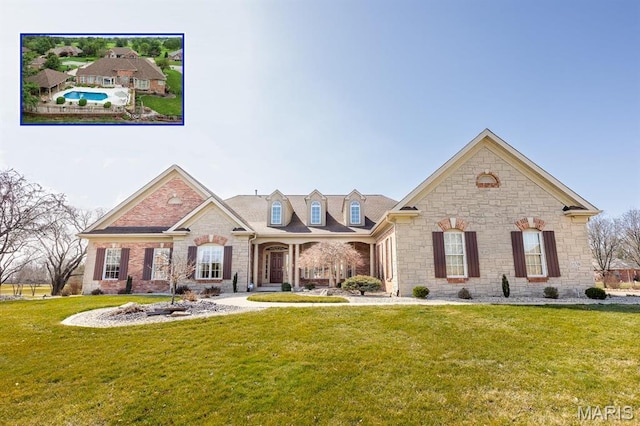 view of front facade with a front yard and stone siding