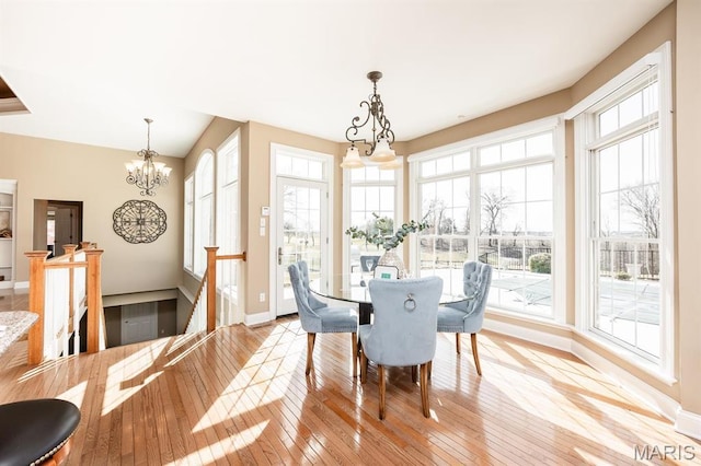 dining room featuring a chandelier, light wood-type flooring, and baseboards